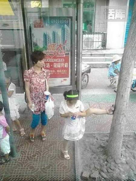 Китайская девочка держит дерево ногой