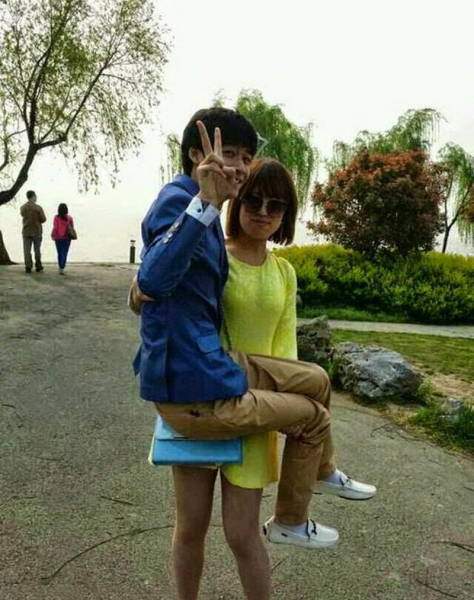Китайская девушка держит парня на руках
